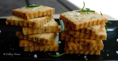 I have been thinking of making these crackers for like past 2 months, but every time I though of making these, I baked something else. :P I came up with this recipe last summer when I was on diet :P and wanted some light snack to eat with my afternoon tea or juice. The first time I made these crackers, it wasn't a great success but over the time I think I have perfected my recipe. It's a gluten free recipe so good news for all of those who are looking for gluten free recipes! :) Before I share this recipe, there is one thing I would like to mention, if you have a food processor, go ahead and use it. This dough is a little bit tricky to handle and also breaks while rolling out. If you don't have a food processor, then use a pastry blender or 2 knifes to cut the butter. So let's get to the recipe, I hope you guys like it! :) Ingredients: 3/4 cup sorghum flour 1/4 cup fine corn meal 1/4 cup rice powder 1/2 tsp baking powder 4 tbsp very cold butter cut in pieces 5-7 tbsp very cold ice water 3/4 tsp salt 2 pinches red chilli flakes 1/2 tsp crushed black pepper Few pinches of dried rosemary, thyme and oregano Directions: If using pastry blender, add in all the dry ingredients and spices in a bowl. Whisk them nicely. Add in the butter and start cutting the butter into the flour mixture. When the butter is all mixed in with the flour, start adding water. I added about 7 tbsp water. You may need less water if the flour is fine. Also if you are making this dough in a food processor then add less water as the dough comes together very quickly. Now make a disk of this dough. Wrap it in a cling film and keep it in a freezer for about 10-15 minutes. In the mean while preheat your oven to 200 degrees celsius or 400 degrees fahrenheit. Line the baking sheet with parchment paper. After the dough is well rested, roll out into a 20 cm circle. While you are rolling, the dough might break apart, you can lightly pat it to keep it together. Using a knife or pastry cutter, cut the rolled up sheet into 1 inch squares. Prick the each squares with a fork. Carefully place all the squares on to a lined baking sheet. Bake them in a preheated oven for 20 minutes. After they are baked, keep them in the oven for about 5 minutes and then take them out. Place on a wire rack to cool off. Serve and enjoy!!